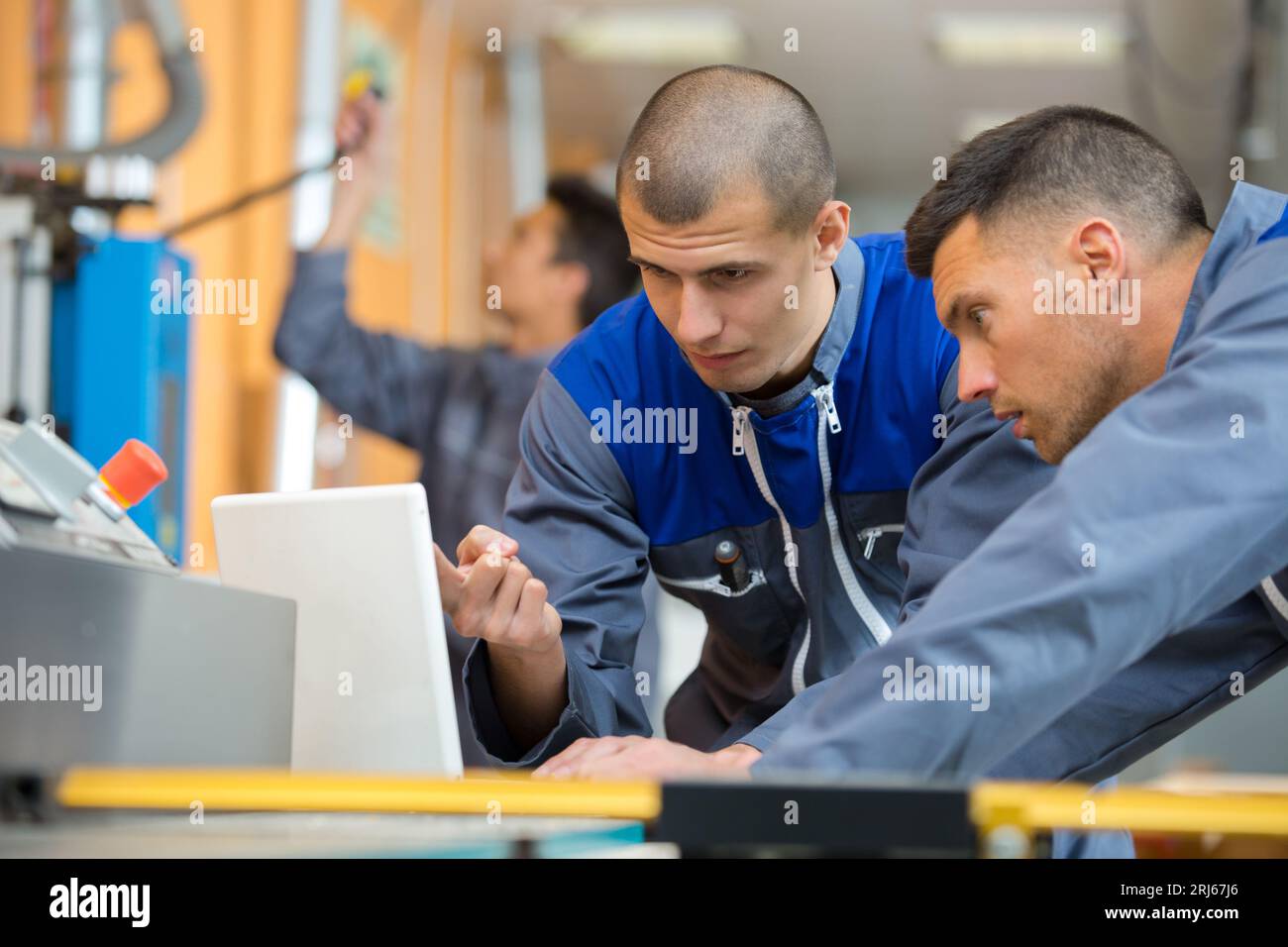 apprentices being shown computer control panel in factory Stock Photo