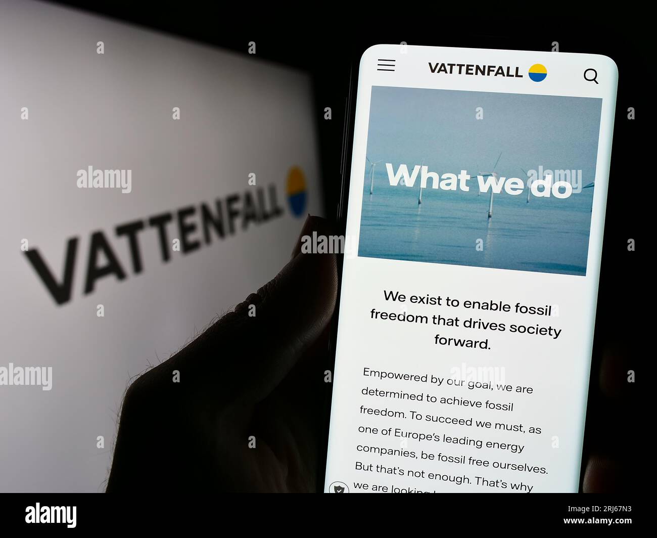 Person holding cellphone with webpage of Swedish energy company Vattenfall AB on screen in front of logo. Focus on center of phone display. Stock Photo
