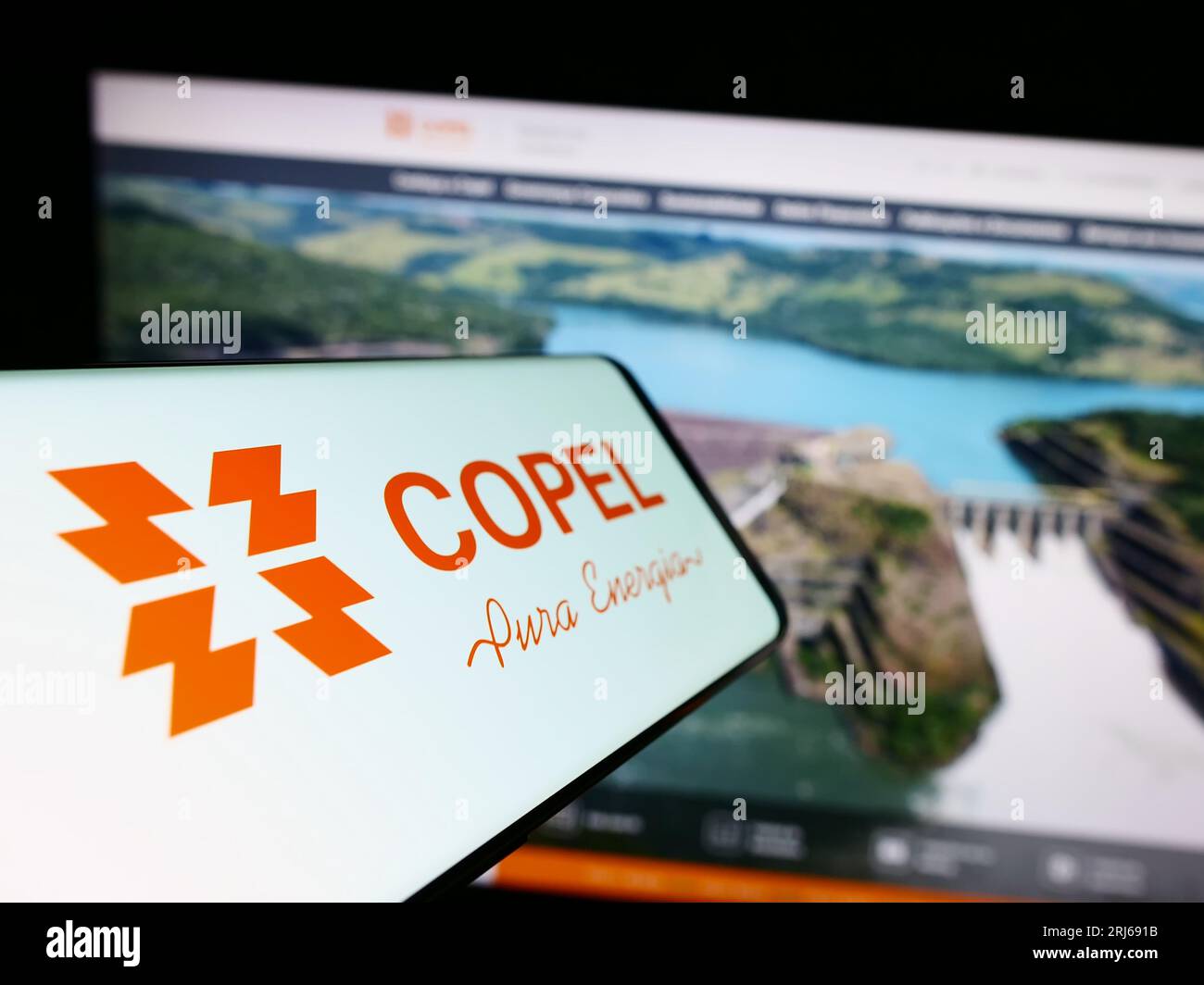 Smartphone with logo of company Companhia Paranaense de Energia (Copel) on screen in front of website. Focus on center-left of phone display. Stock Photo