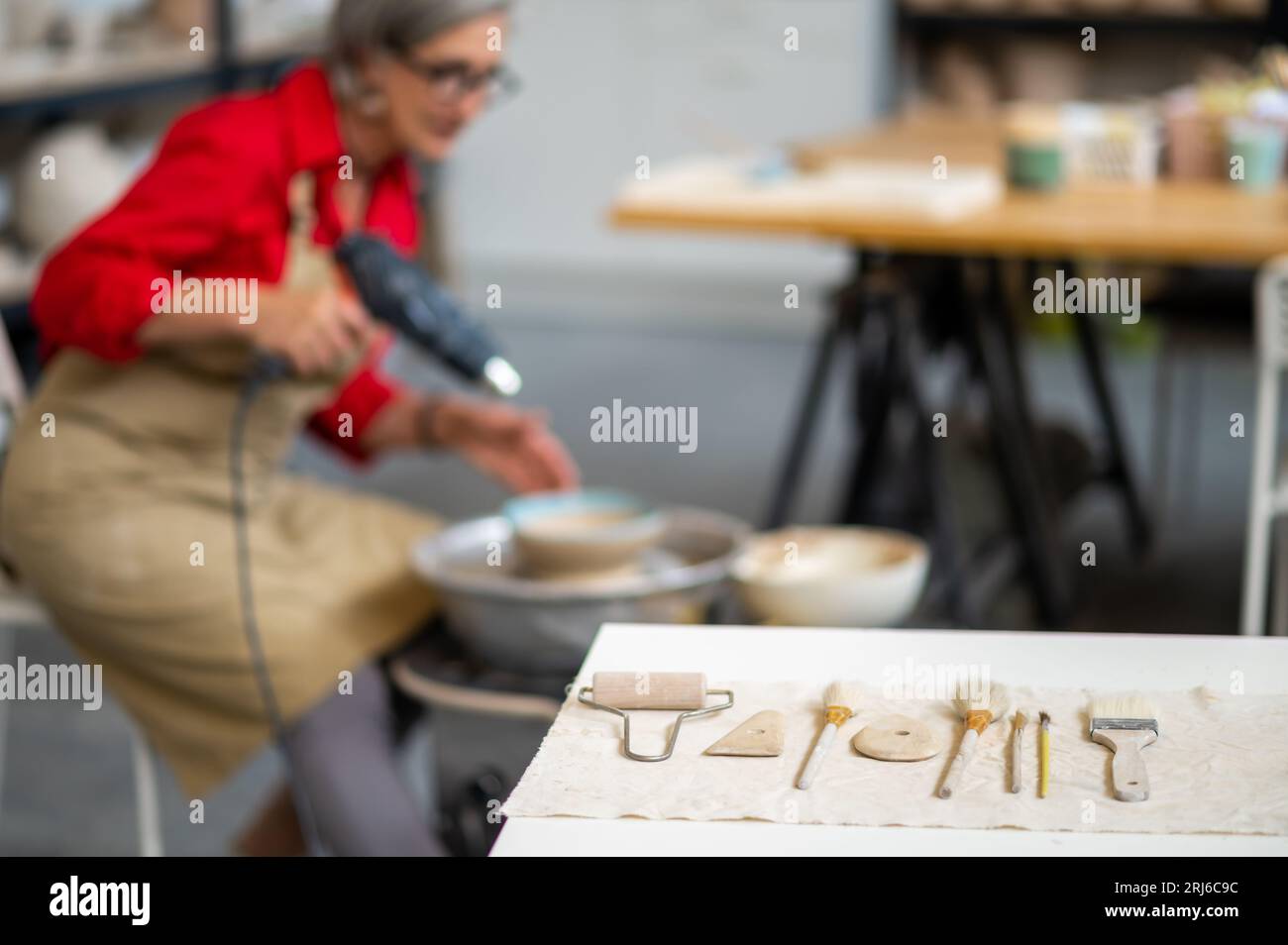 Pottery equipments with woman master drying clay sculpture with heat