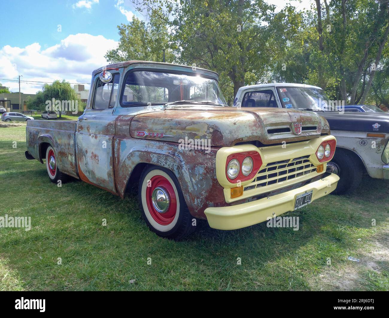 An old rusty utility 1960 Ford F 100 Styleside bed pickup truck on the lawn Stock Photo