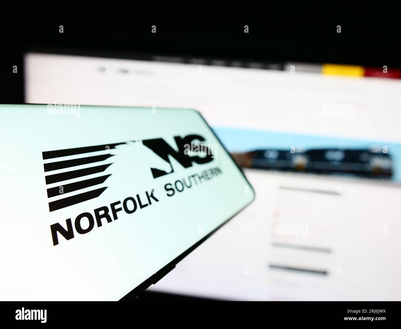 Mobile phone with logo of American railway company Norfolk Southern Corp. on screen in front of business website. Focus on left of phone display. Stock Photo