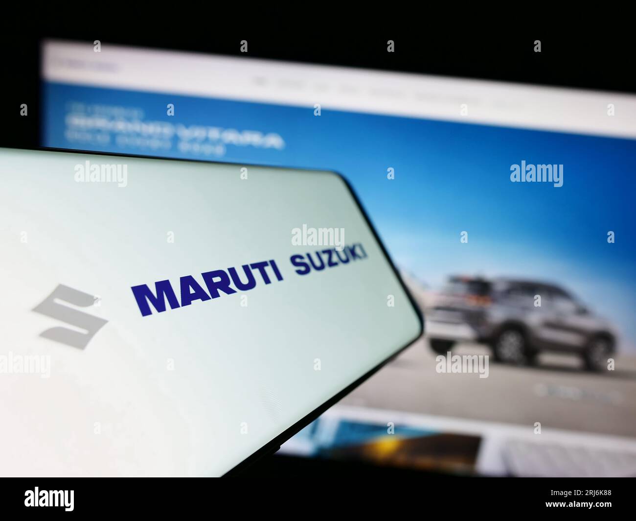 Smartphone with logo of Indian company Maruti Suzuki India Limited on screen in front of business website. Focus on center-left of phone display. Stock Photo