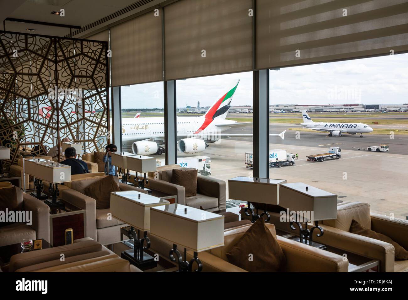 UK, England, London Heathrow Airport, Emirates Business Class Lounge, seating overlooking A380 at gate Stock Photo
