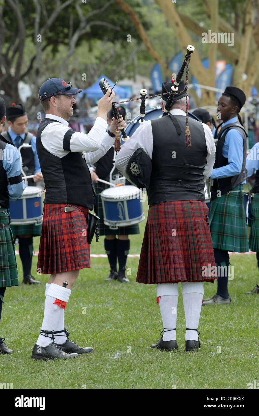 Adult man in Scottish kilt tuning bagpipe music instrument, pipes