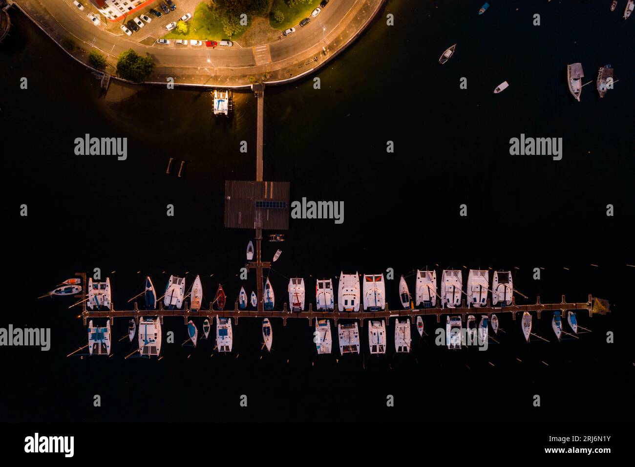 An aerial view of a peaceful marina area featuring a pier and boats ...