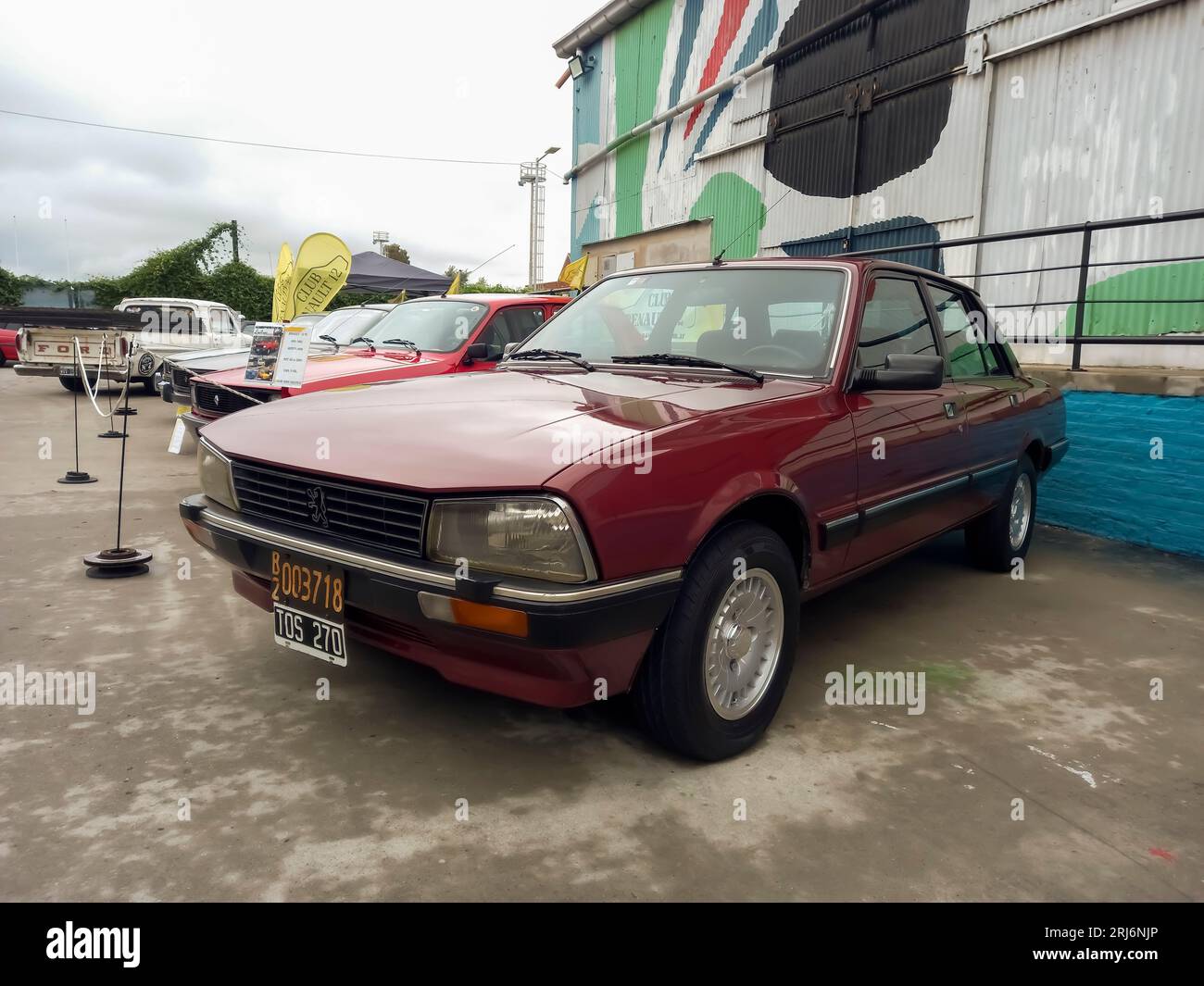 Old stylish red burgundy 1980s Peugeot 505 sedan. Industrial background. Expo Fierro 2023 classic car show. Stock Photo