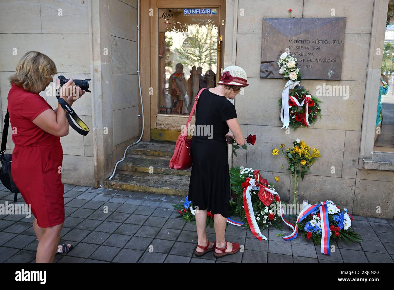 Brno, Czech Republic. 21st Aug, 2023. People lay wreaths to the commemorative plaque for Danuse Muzikarova (at the corner of Moravske namesti square and Rasinova street), who was shot dead by communist Czechoslovak armed forces, Police and People's Militia (LM) in August 1969 on the first anniversary of the Warsaw Pact invasion in August 1968, in Brno, Czech Republic, on August 21, 2023. Credit: Vaclav Salek/CTK Photo/Alamy Live News Stock Photo