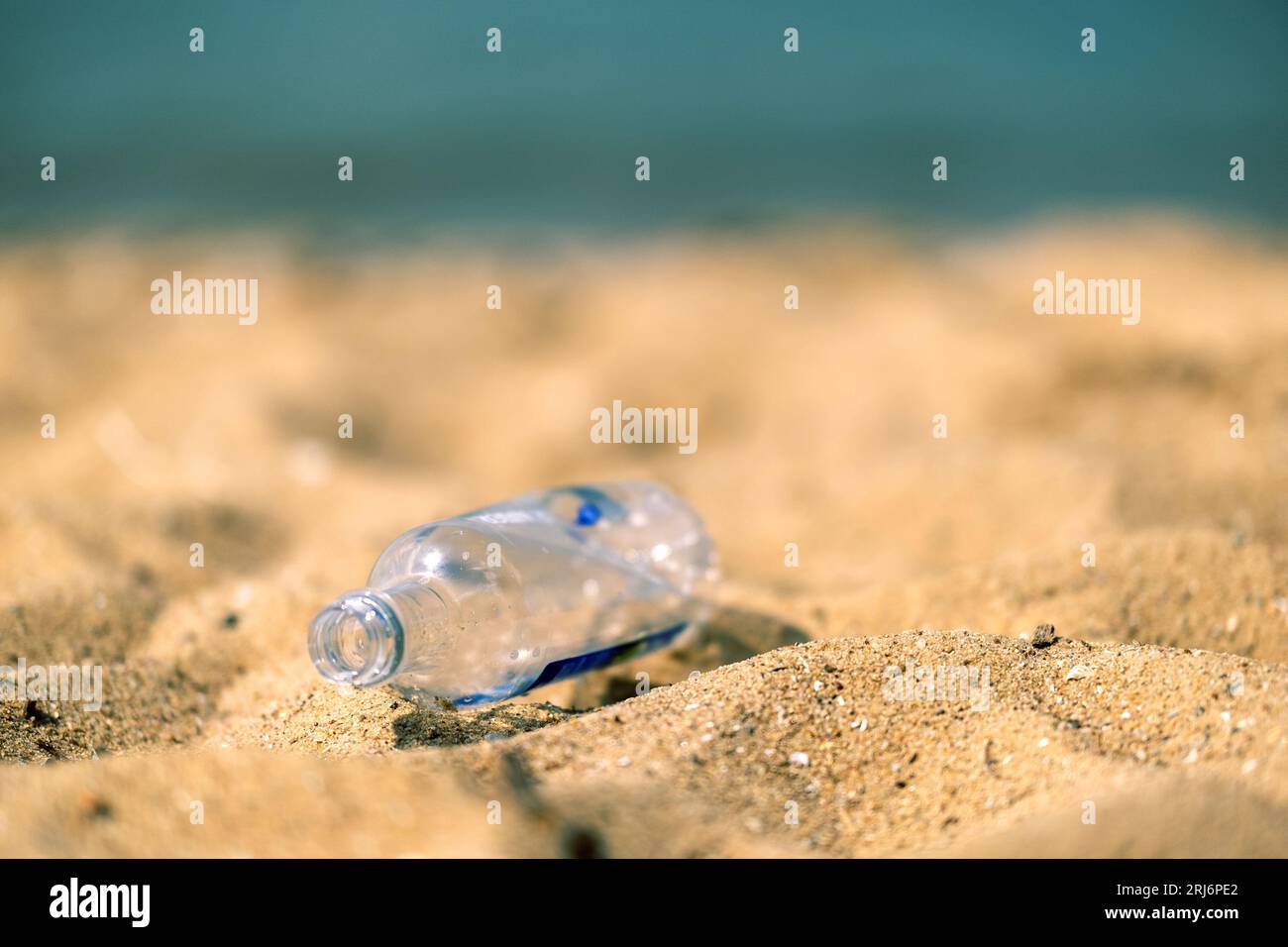 Plastic trash at the sandy beach. Plastic pollution concept. Singleuse plastic is a human