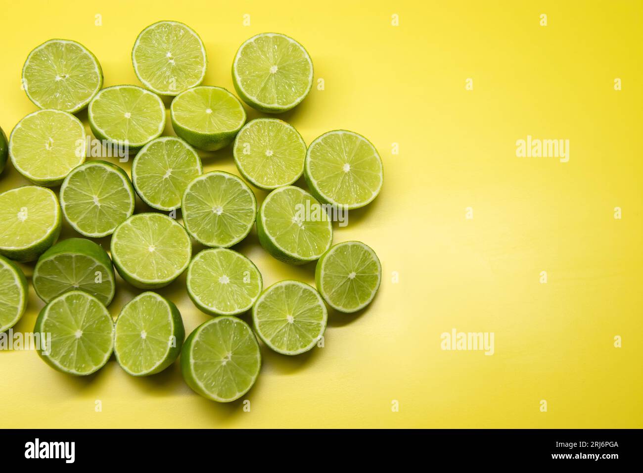 A vibrant yellow background with a plentiful supply of lime slices ...