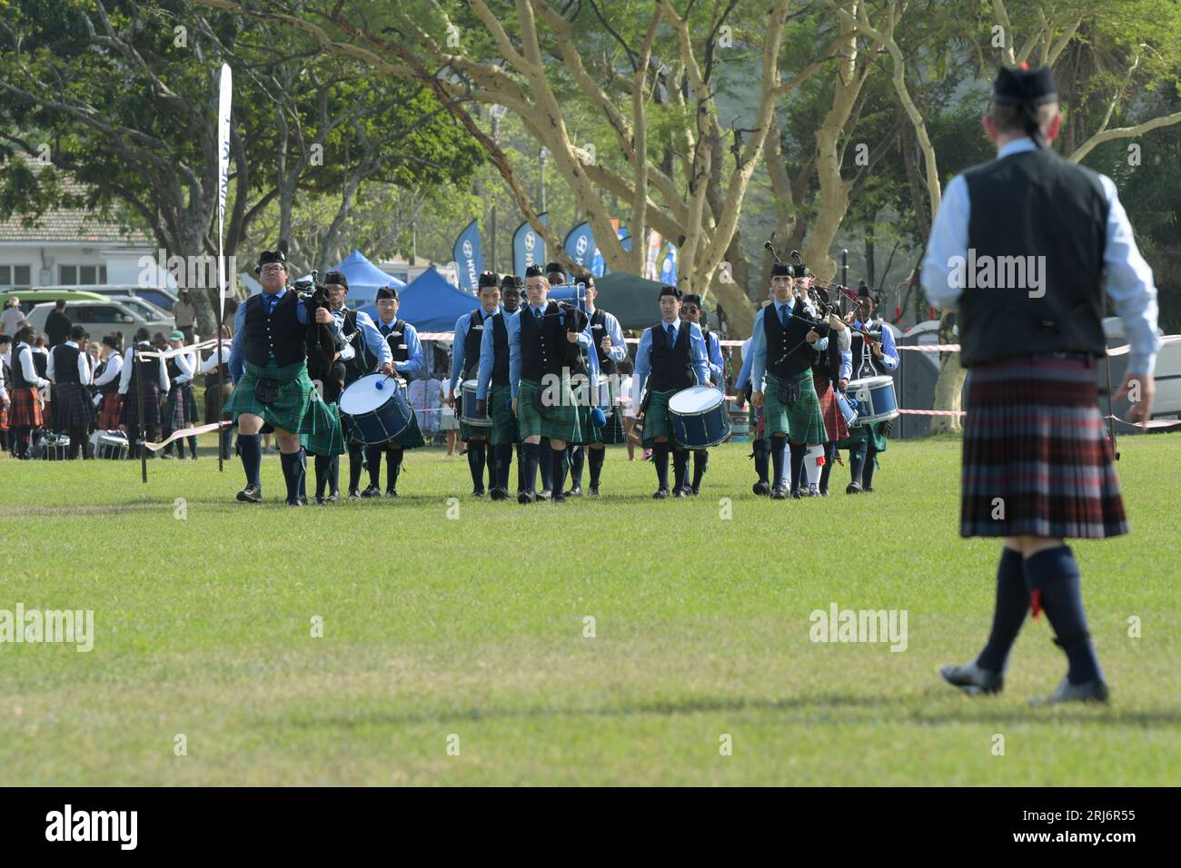 People marching, St Benedict Scottish pipes and drums band walk to