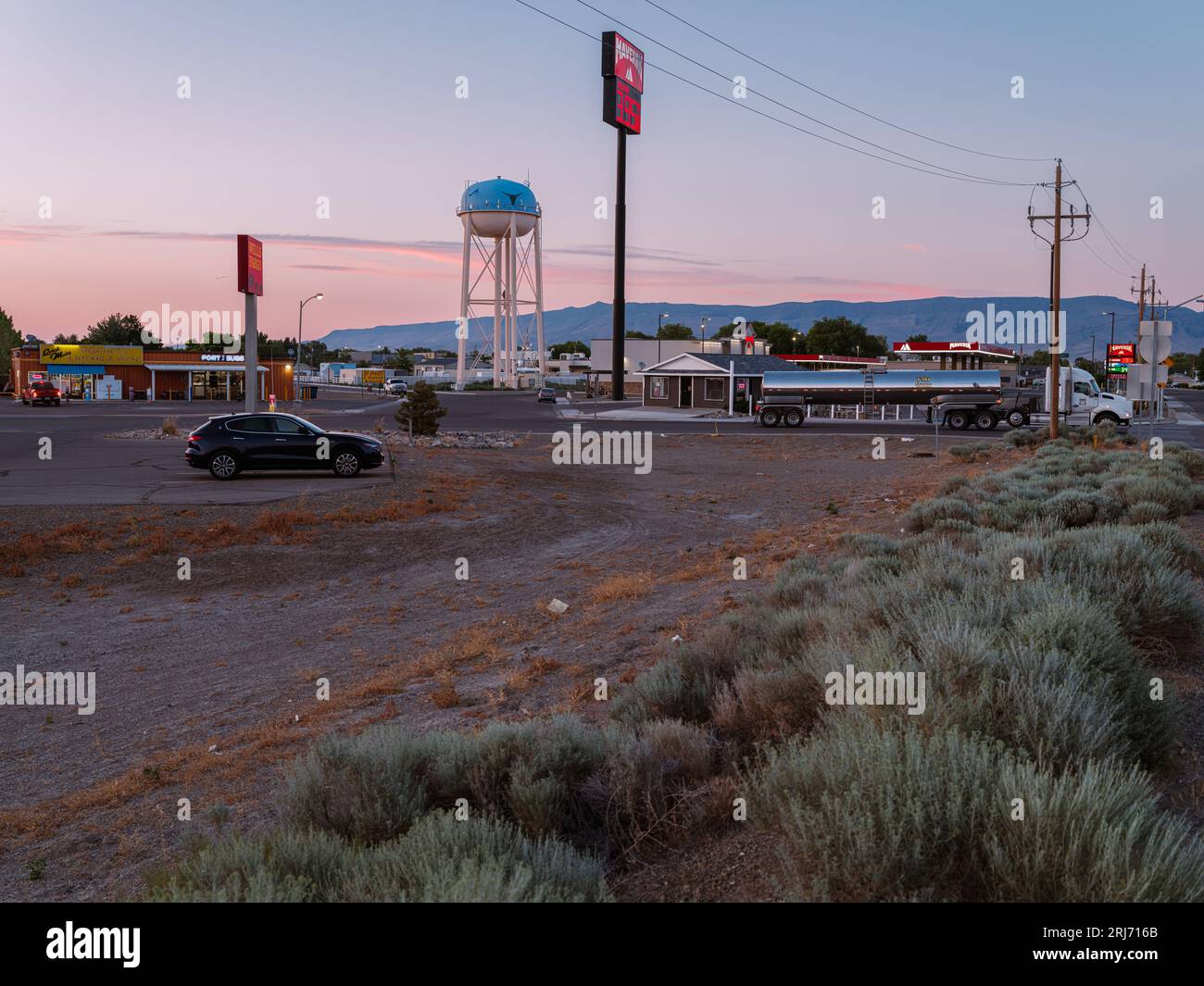 An evening view at Battle Mountain of a tall Water tower against a pink