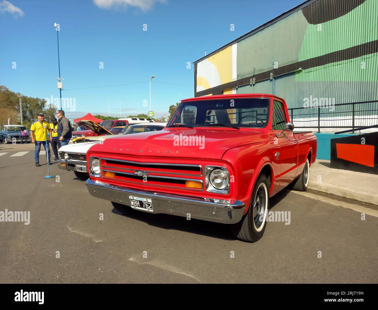 Old red 1967 Chevrolet C10 pickup truck in the street. Colorful industrial background. Classic car show Stock Photo