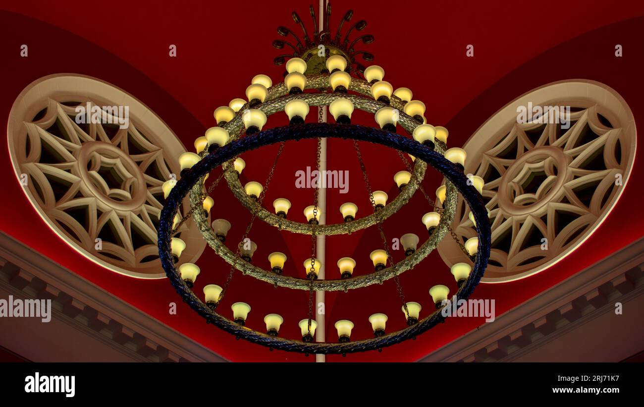 A circular light fixture with decorative elements suspended from the