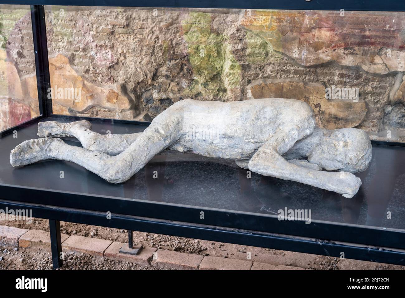 Plaster cast of a victim of the eruption in the Macellum (marketplace) in the ruins of the ancient city of Pompeii in Campania Region, Southern Italy Stock Photo