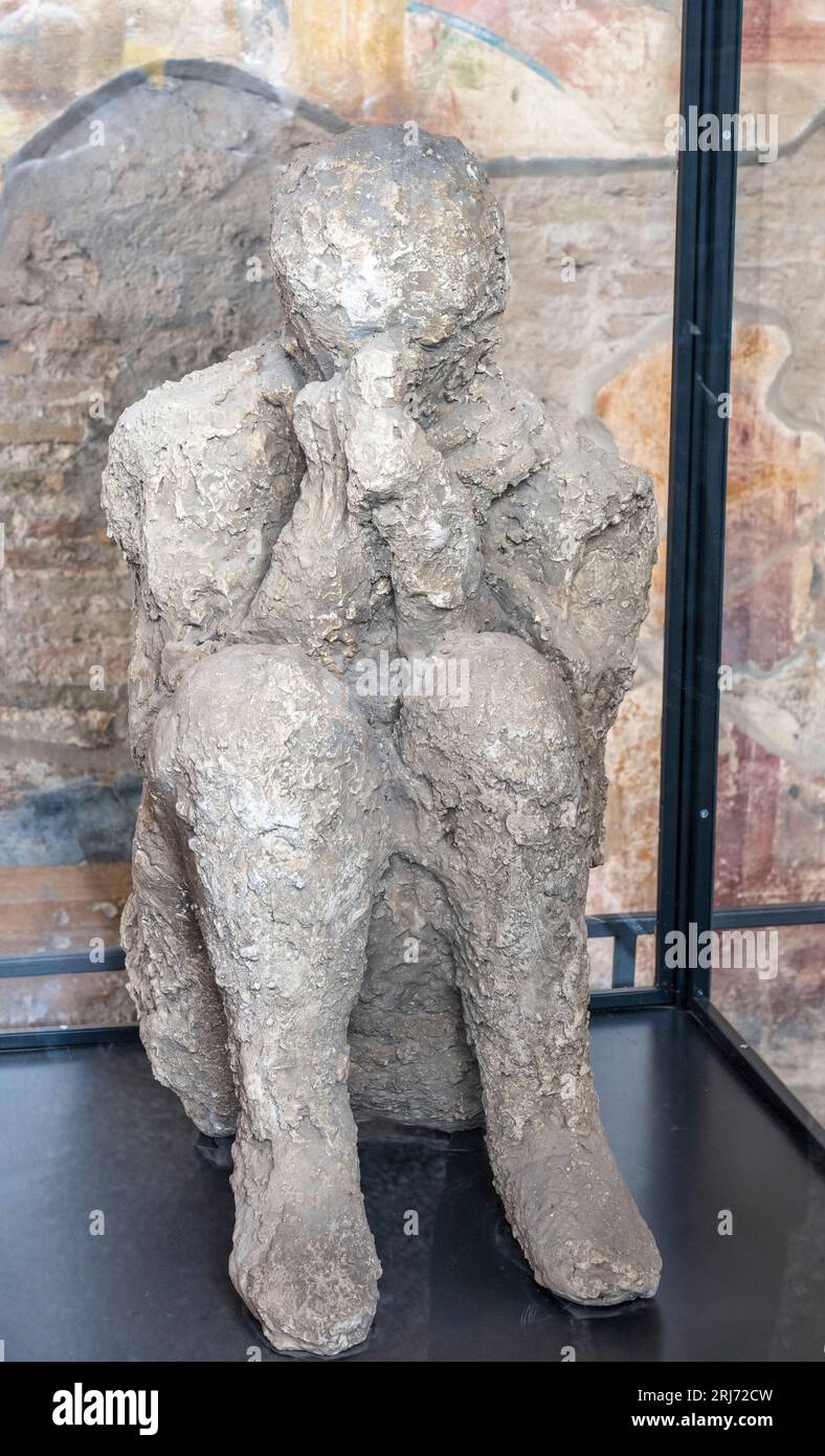 Plaster cast of a victim of the eruption in the Macellum (marketplace) in the ruins of the ancient city of Pompeii in Campania Region, Southern Italy Stock Photo