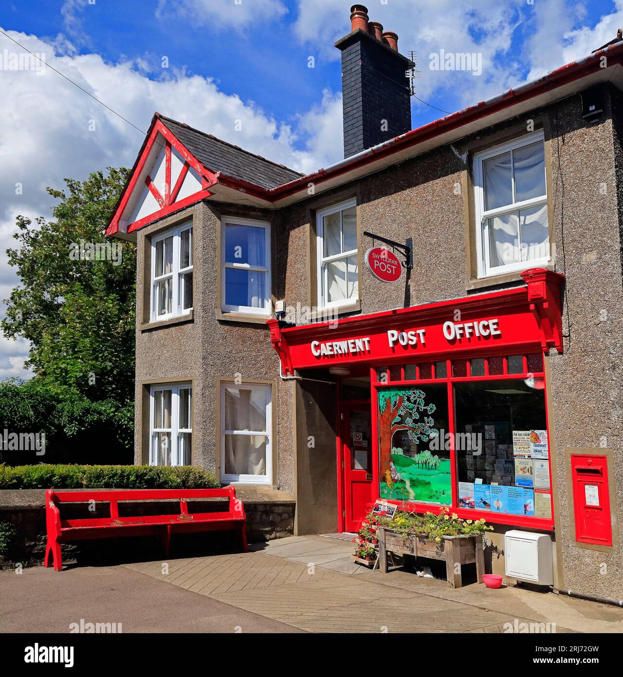 Caerwent Post Office, flower planter and sleeping ca - traditional looking red painted Post Office at Caerwent village, South Wales. August 2023 Stock Photo