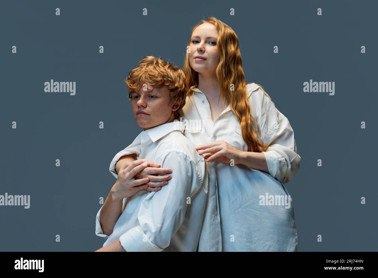 Young beautiful couple hugging in white t-shirts. Red hair woman in hug ...