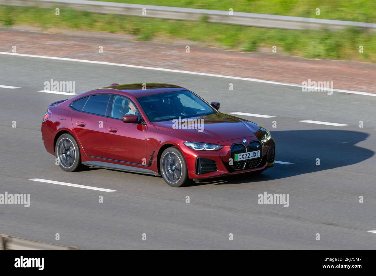 2022 Red BMW I4 Edrive40 M Sport; travelling at speed on the M6 motorway in Greater Manchester, UK Stock Photo