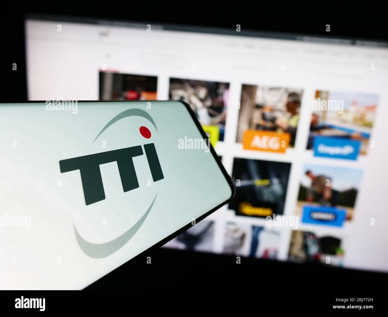 Smartphone with logo of Techtronic Industries Company Limited (TTI) on screen in front of website. Focus on center-right of phone display. Stock Photo