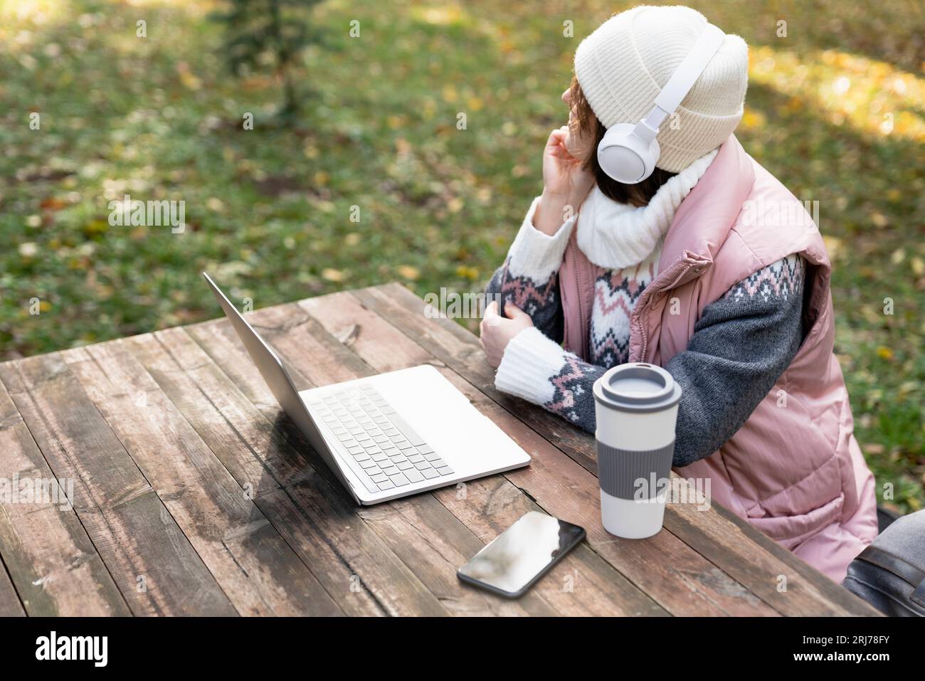 Freelancer working on laptop in autumn park. Stock Photo