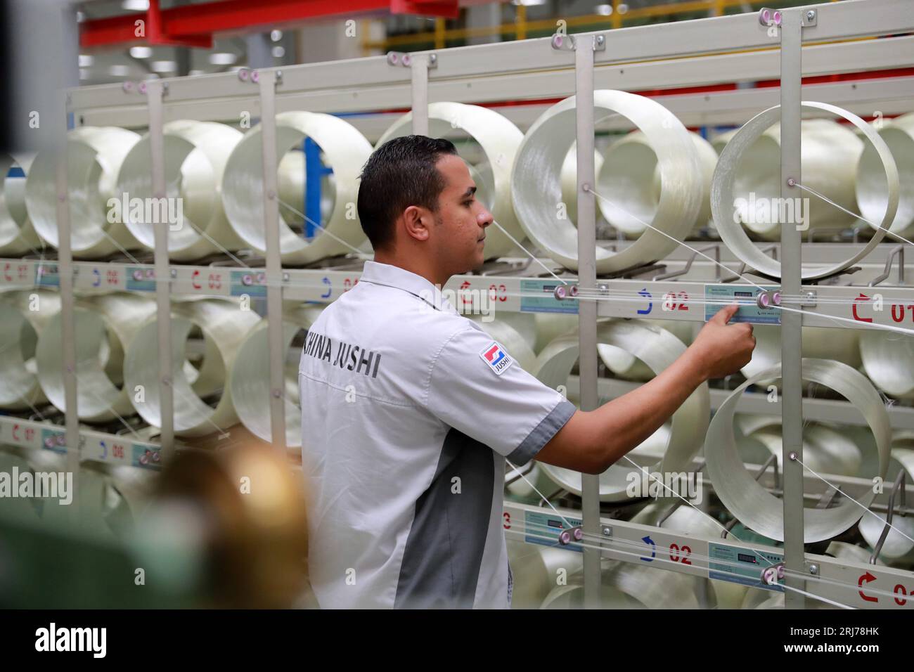 Cairo, Egypt. 10th Aug, 2023. Ahmed Soliman, deputy general manager of Jushi Egypt Fiberglass Co., Ltd., checks on the fiberglass production line of Jushi Egypt at the China-Egypt TEDA Suez Economic and Trade Cooperation Zone in Suez province, Egypt, Aug. 10, 2023. TO GO WITH 'Explainer: How a joint economic and trade cooperation zone connects the Bohai and Red seas' Credit: Sui Xiankai/Xinhua/Alamy Live News Stock Photo