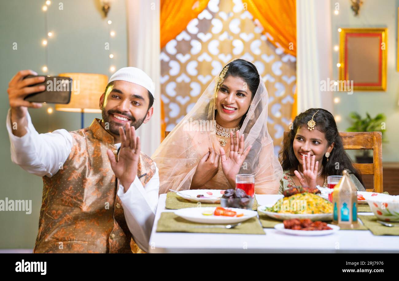 Happy smiling indian muslim family on video call on mobile phone during