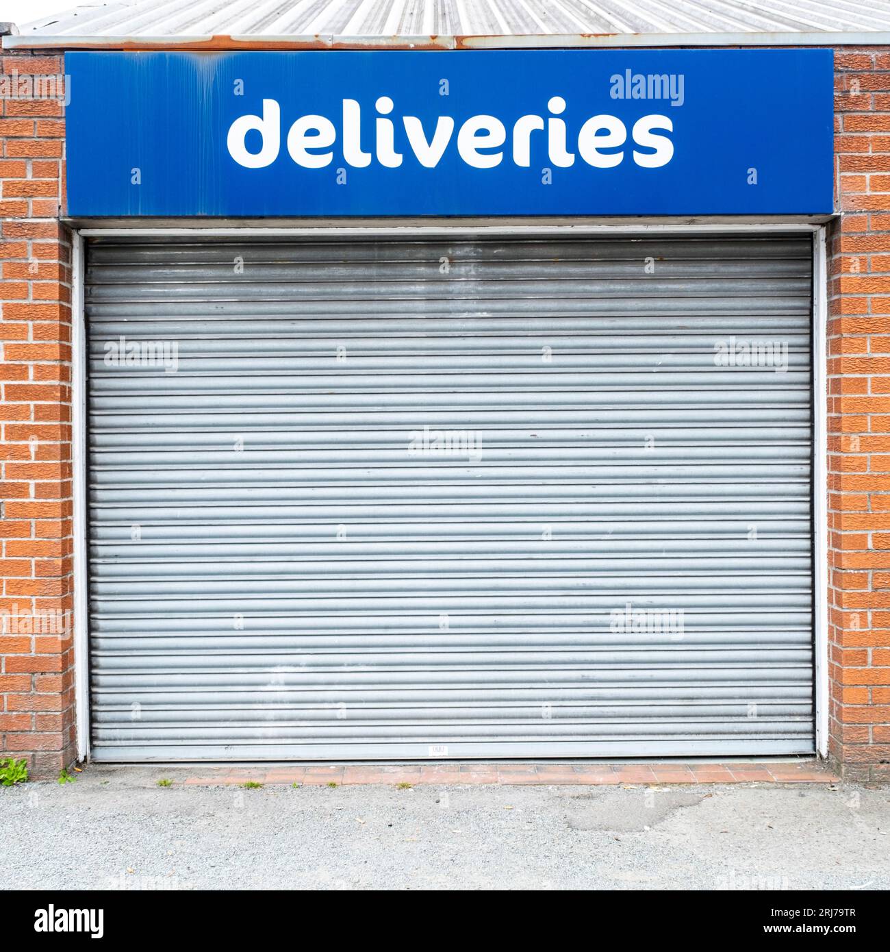 Deliveries sign above shuttered entrance Stock Photo