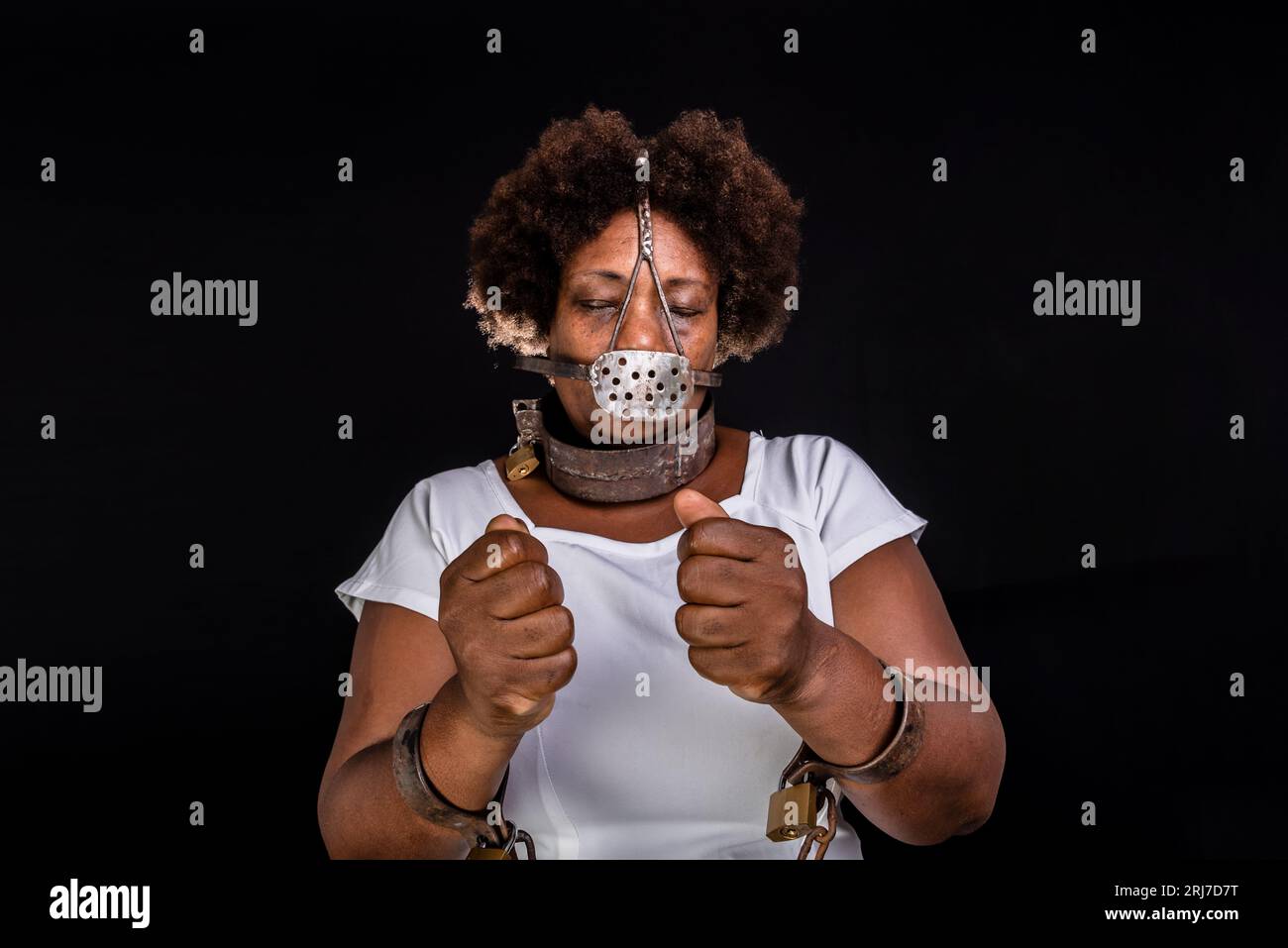 Portrait of a black woman in chains with an iron mask over her mouth.  Slavery in Brazil. Studio reproduction Stock Photo - Alamy