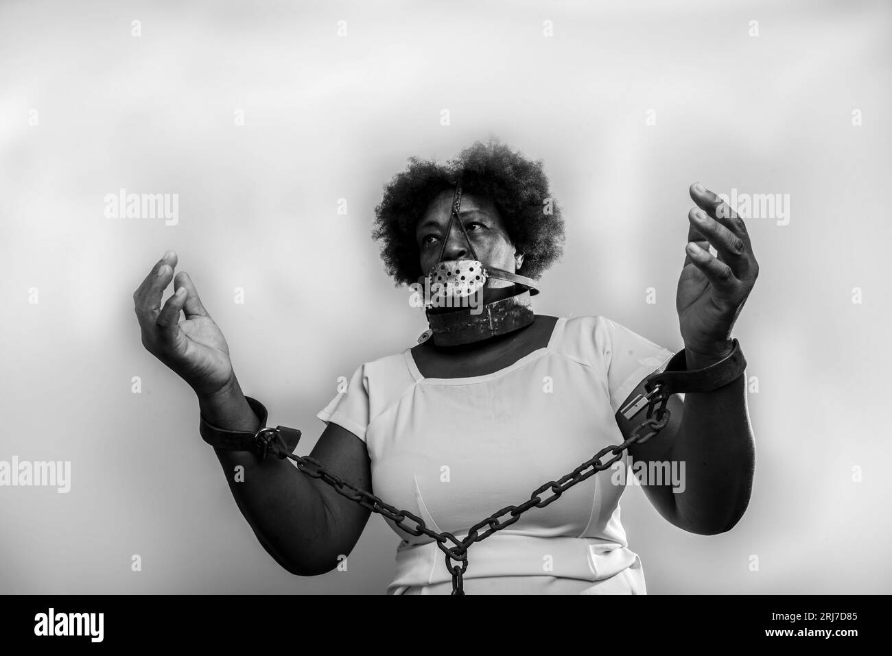 Portrait of a black woman in chains with an iron mask over her mouth.  Slavery in Brazil. Studio reproduction Stock Photo - Alamy