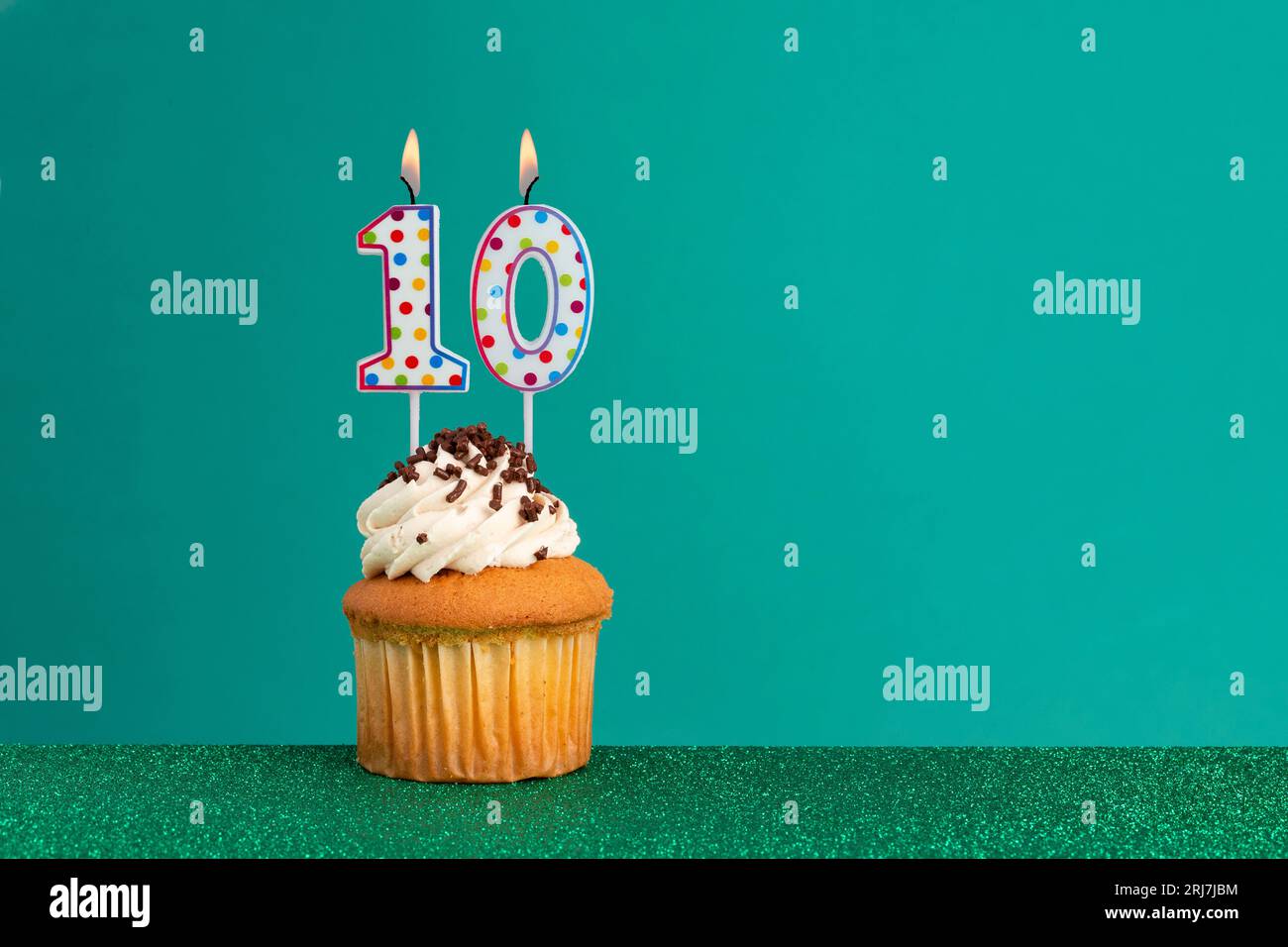 Cupcake with sparkling candle for 39th birthday or anniversary with big  number in white with yellow streamers on blue table with dark background  full Stock Photo - Alamy