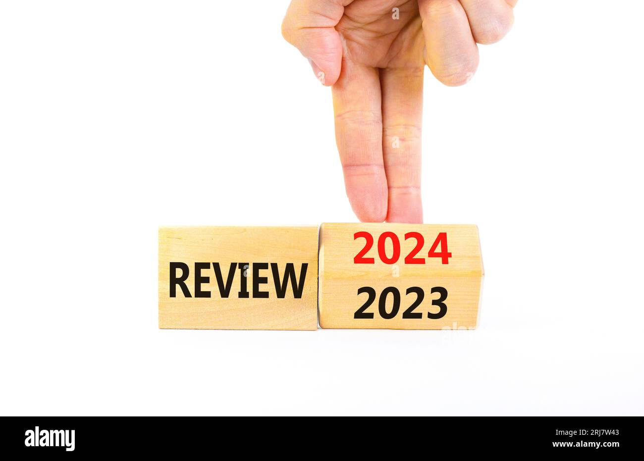 2024 review new year symbol. Businessman turns a wooden cube and changes words Review 2023 to Review 2024. Beautiful white background, copy space. Bus Stock Photo