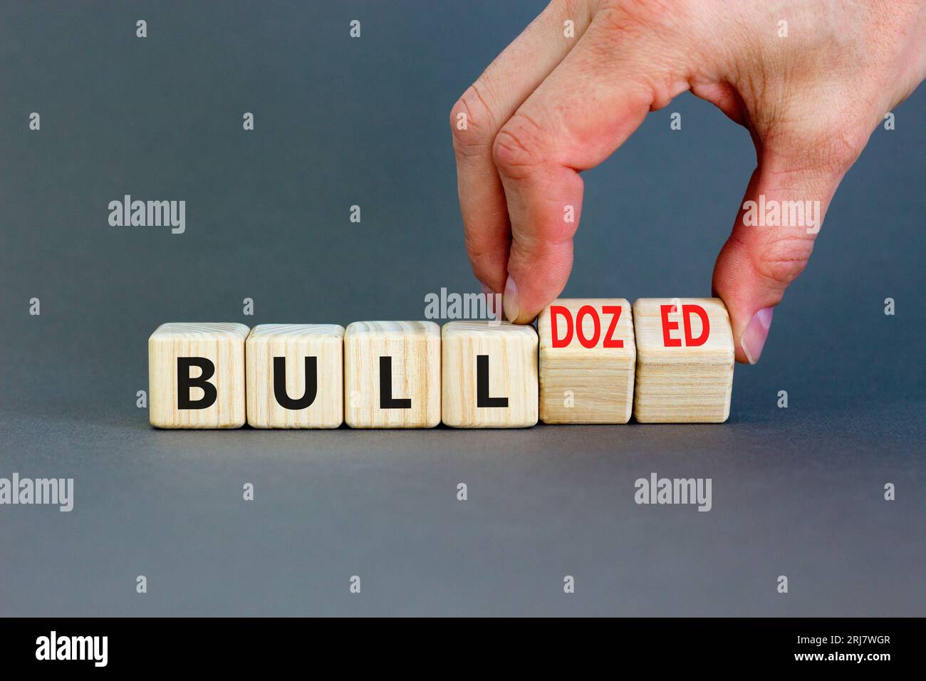 Bull or bulldozed symbol. Businessman turns wooden cubes and changes