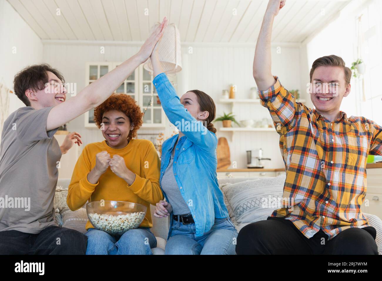 https://c8.alamy.com/comp/2RJ7WYM/group-of-friends-watching-sport-match-soccer-football-game-on-tv-happy-football-fans-celebrating-victory-at-home-friendship-sports-entertainment-concept-diverse-buddies-having-fun-together-at-home-2RJ7WYM.jpg