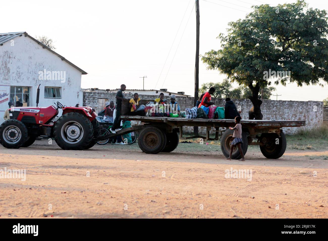 Women and children ride at the back of an open tractor at a growth point in Selous, posing a serious danger to themselves as well as their children. Zimbabwe. Stock Photo