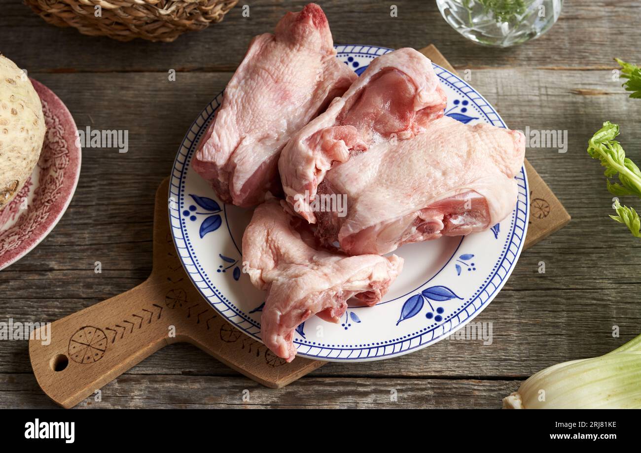 Frozen chicken backs and fresh vegetables Ingredients for bone broth or soup on a table Stock
