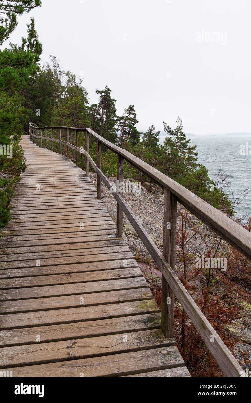 Elevated seaside wooden walkway on a cliff by the Baltic sea in Mariehamn, Åland Islands, Finland, on a cloudy day. Stock Photo