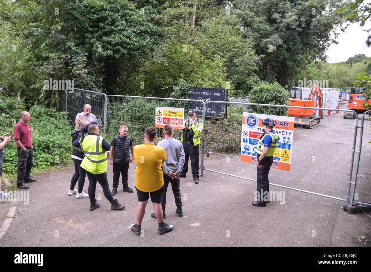 Himley Road, Himley, 21st August 2023: Angry protesters turned up at the site of The Crooked House in Himley, Staffordshire after demolition crews from the Putnam company turned up on Monday afternoon. Two diggers and several work vans are on site along with a welfare unit and a security dog. Staffordshire Police are also on scene keeping the peace. Staffordshire Police Statement: 'We are aware of a small protest earlier in the day at #Himley as we continue to investigate an arson attack at The Crooked House. 'At 1. Credit: Stop Press Media/Alamy Live News Stock Photo