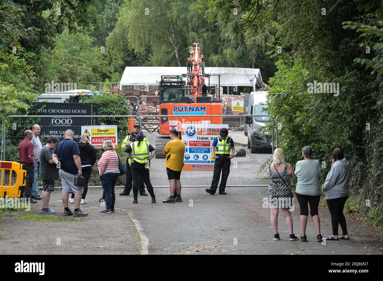 Himley Road, Himley, 21st August 2023: Angry protesters turned up at the site of The Crooked House in Himley, Staffordshire after demolition crews from the Putnam company turned up on Monday afternoon. Two diggers and several work vans are on site along with a welfare unit and a security dog. Staffordshire Police are also on scene keeping the peace. Staffordshire Police Statement: 'We are aware of a small protest earlier in the day at #Himley as we continue to investigate an arson attack at The Crooked House. 'At 1. Credit: Stop Press Media/Alamy Live News Stock Photo