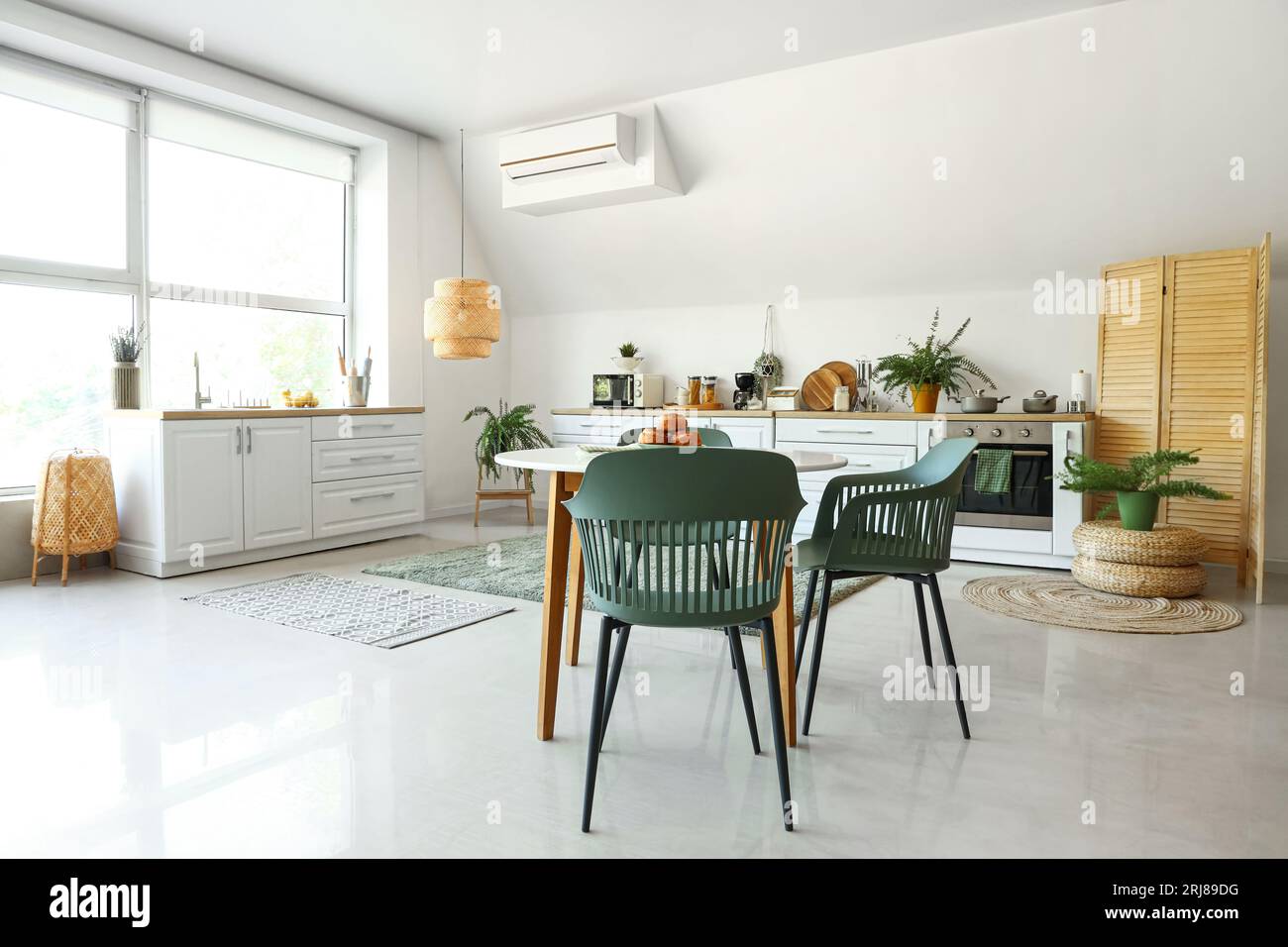 Interior of modern kitchen with white counters and dining table Stock ...