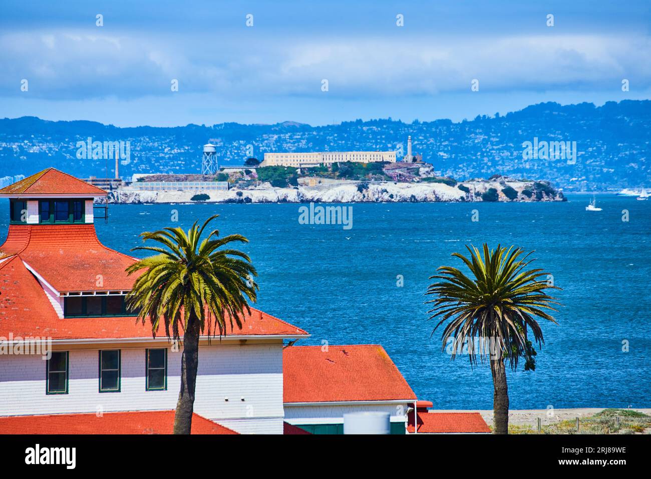 Orange tile roof with palm trees close up and Alcatraz Island in ...