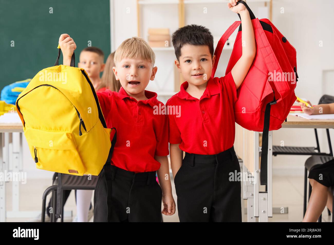 Little boys with backpacks in classroom at school Stock Photo Alamy
