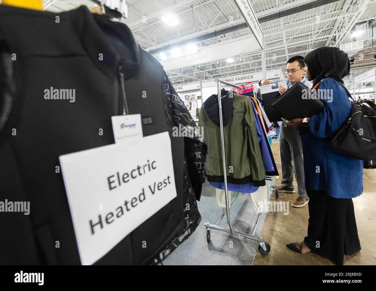 Toronto, Canada. 21st Aug, 2023. An attendee (R) visits a booth at the
