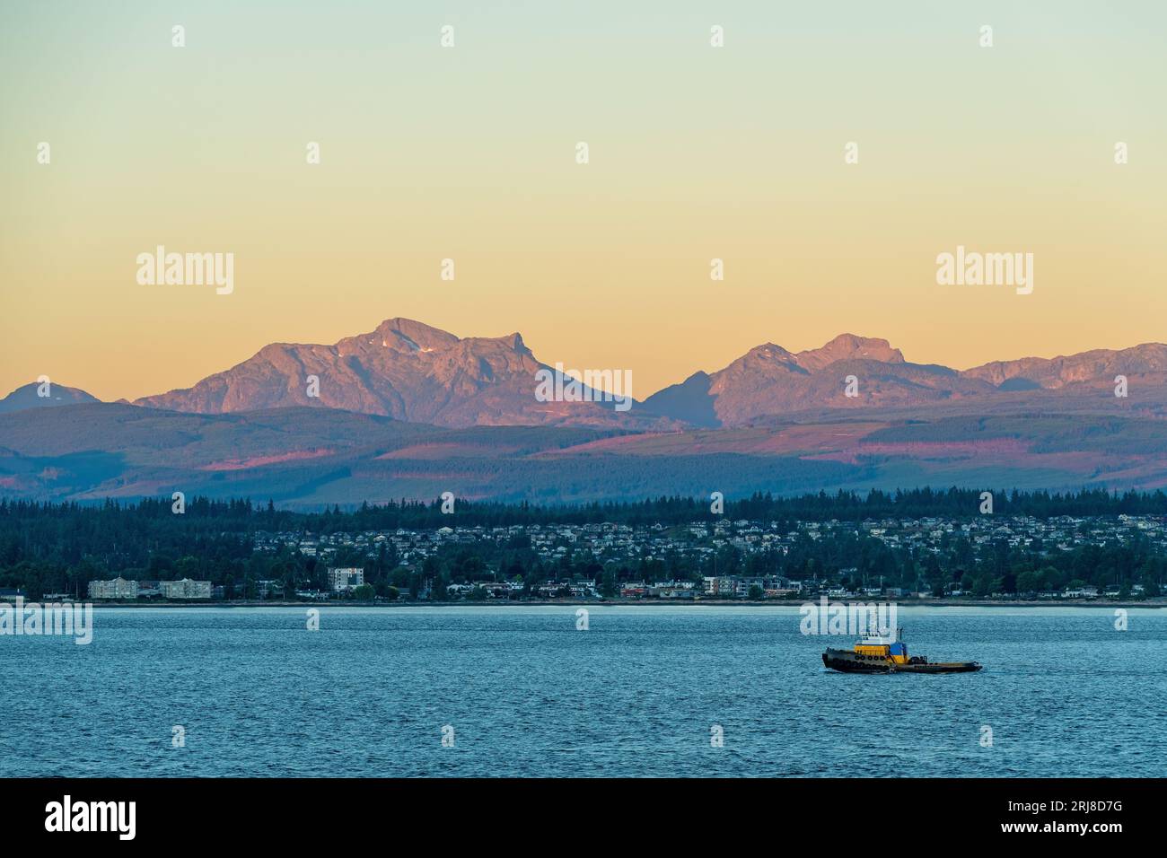 Campbell River skyline at sunrise seen from Quadra Island and Vancouver Island mountain ranges, British Columbia, Canada. Stock Photo