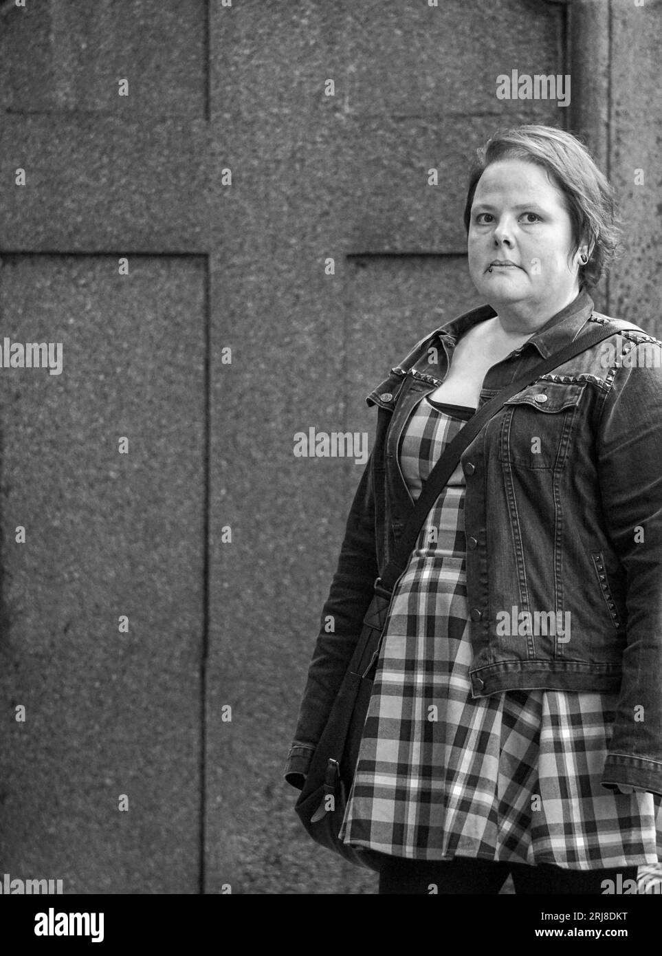 Portrait of a woman standing in front of a wall Stock Photo