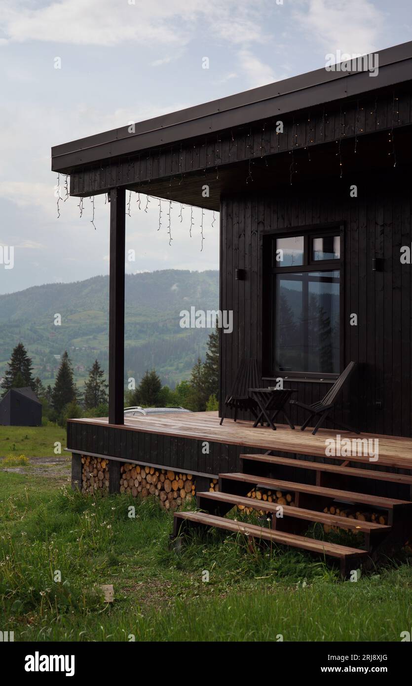 Front view of black modern cabin with terrace on Carpathian mountains Stock Photo