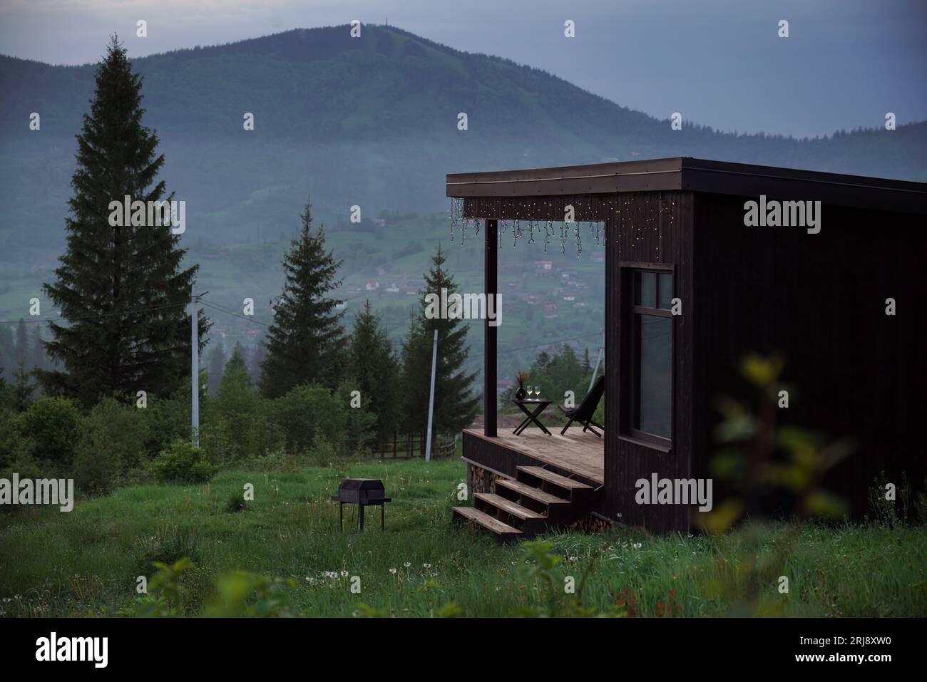 Modern black cabin with terrace on Carpathian mountains in Ukraine Stock Photo