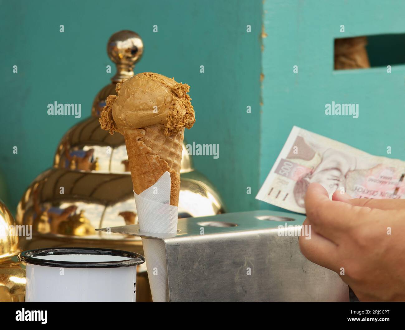 Man buying ice cream at a street market in the centre of Prague, holding a paper bill between his fingers. Stock Photo