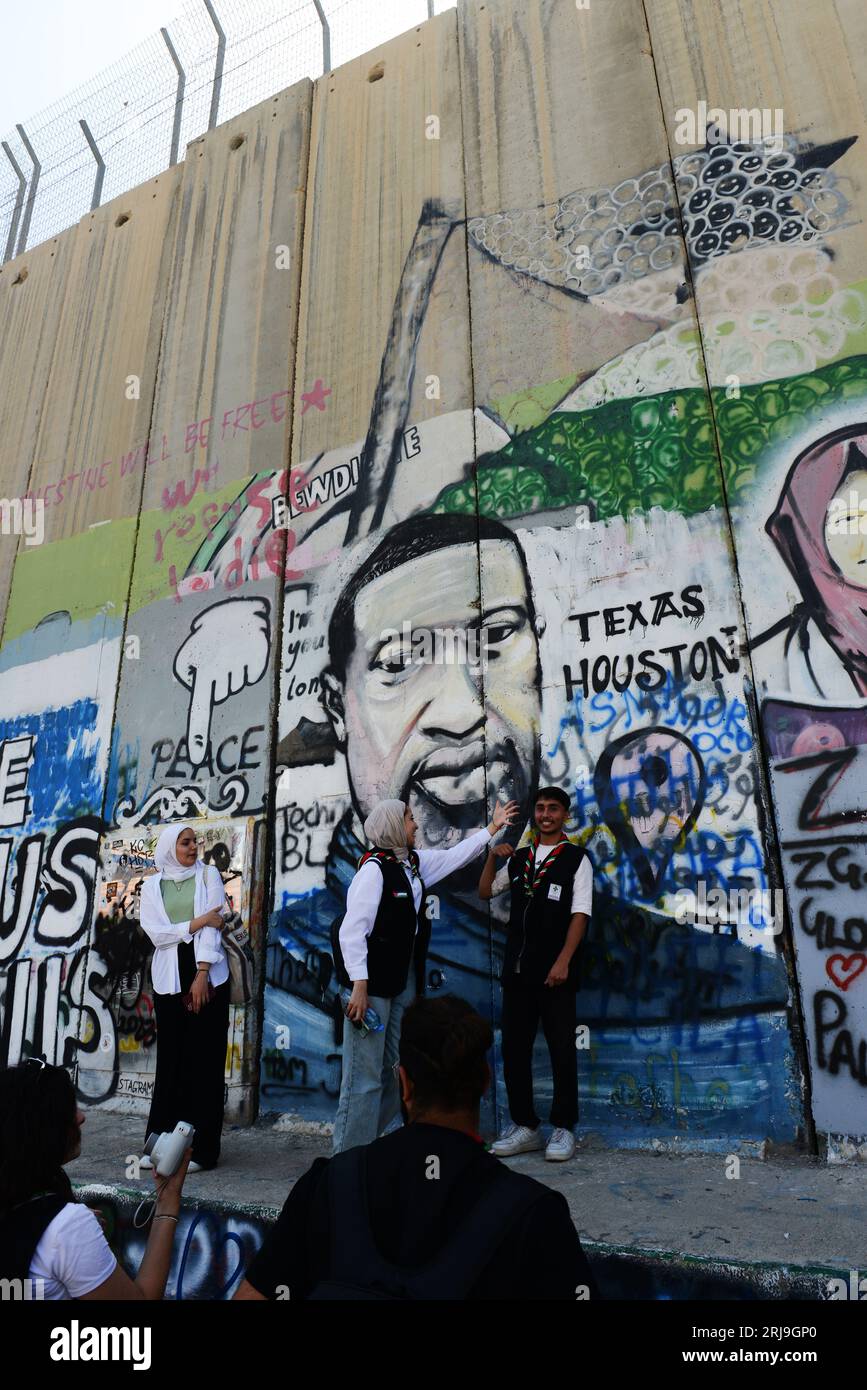 Palesinians posing by the Murals on the Israeli security barrier in Bethlehem, Palestine. Stock Photo
