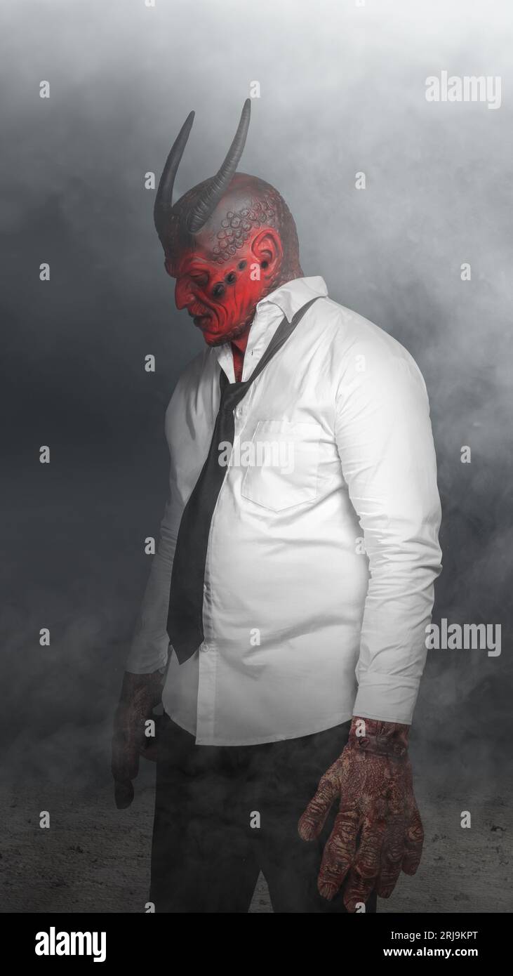 Devilman is standing in the dark background. Scary demon Halloween concept Stock Photo